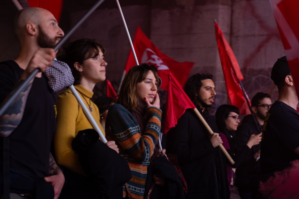 Una fila di manifestanti con bandiere rosse - Francesca Palisi
