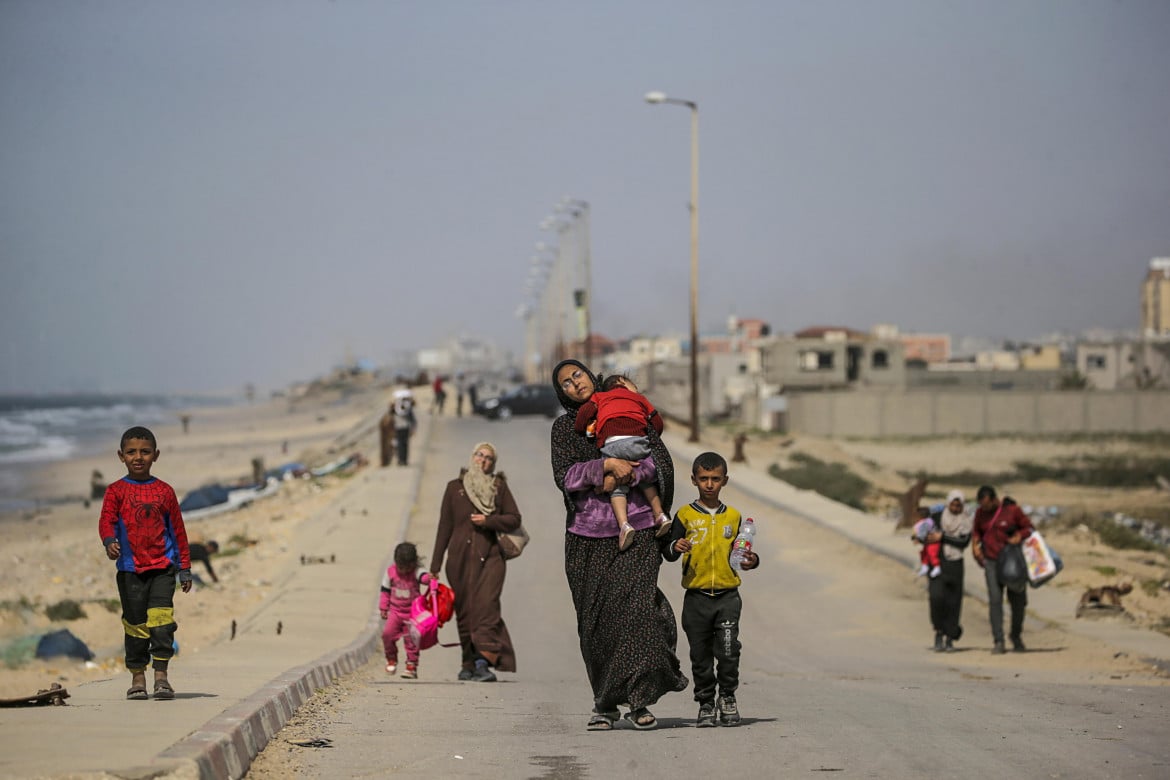 Una famiglia palestinese sfollata su al Rashid Street, in marcia verso sud foto Epa/Mohammed Saber