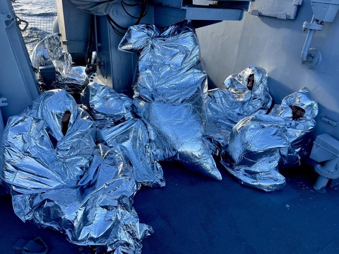 Migranti con le coperte termiche dopo il salvataggio al largo delle coste greche foto Epa