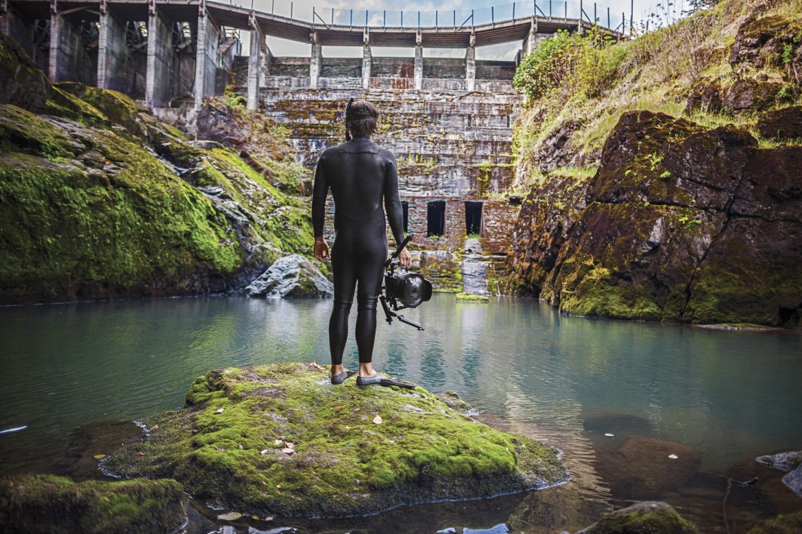 DamNation producer and underwater photographer Matt Stoecker emerges from the icy tail waters below the former Elwha Dam in a scene from DAMNATION. Photo Ben Knight