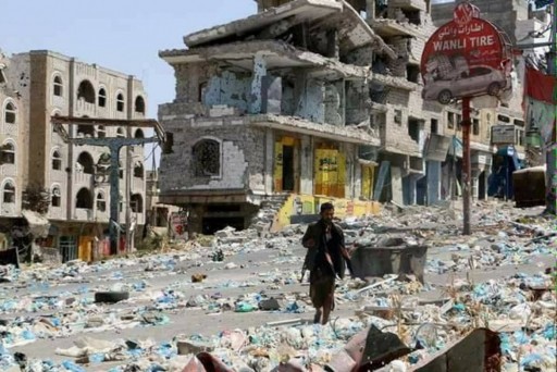 Un combattente Houthi cammina tra strade e edifici distrutti a Sana'a (Foto di Federica Iezzi)