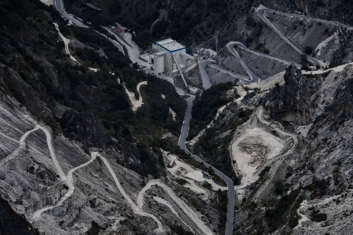 05-vista-panoramica-di-alcune-vie-di-cava-del-bacino-estrattivo-di-carrara-sullo-sfondo-al-centro-l-enorme-impianto-di-frantumazione-marmo-omya-la-multinazion