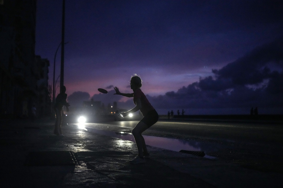 Una donna si prepara a catturare un frisbee lanciato durante un enorme blackout all'Avana a Cuba (Ramon Espinosa, Ap)