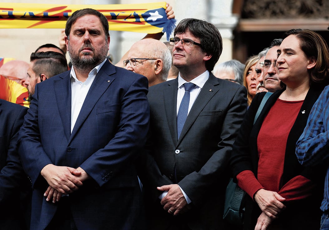 Catalan President Carles Puigdemont (C) is flanked by Barcelona mayor Ada Colau and Vice President Oriol Junqueras as they stand with people in Plaza Sant Jaume during a protest called by pro-independence groups for citizens to gather at noon in front of city halls throughout Catalonia, in Barcelona, Spain October 2, 2017. REUTERS/Juan Medina