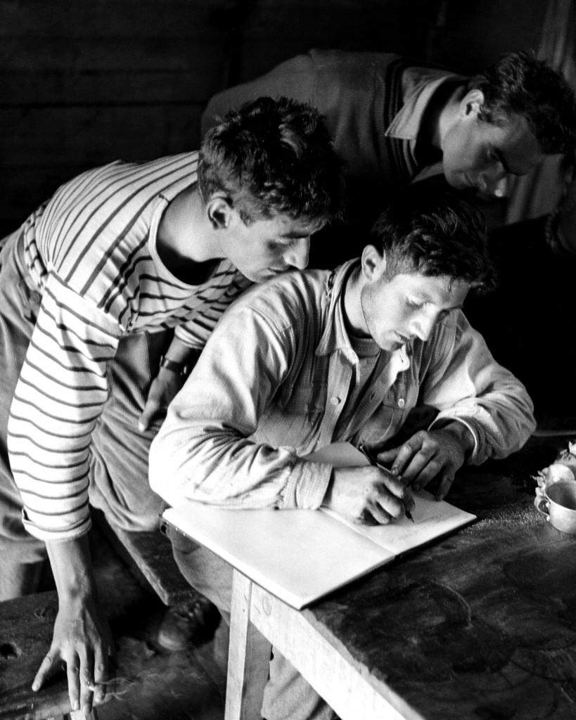 Walter Bonatti compila il diario dell'impresa sul Petit Dru del Monte Bianco nel 1955, foto LaPresse