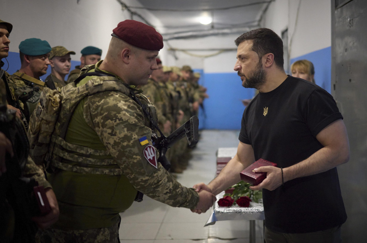 Ukrainian President Volodymyr Zelensky (R) present a state award to a Ukrainian serviceman during his working visit to the Donetsk region, ap