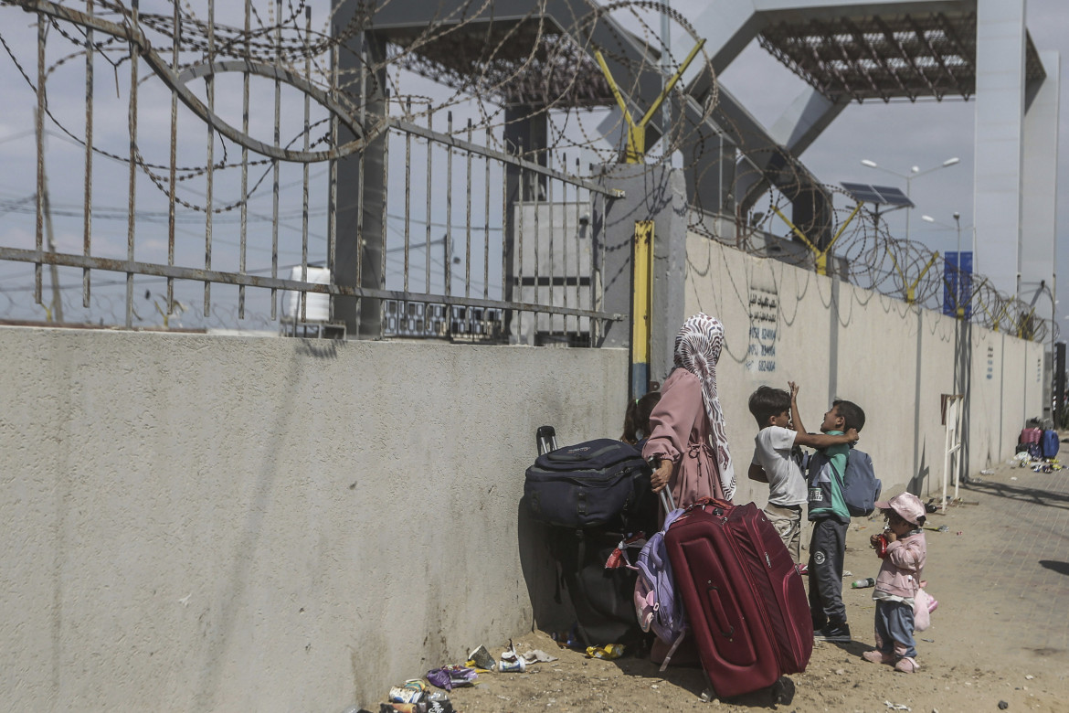 Una famiglia palestinese bloccata al valico di Rafah tra Gaza ed Egitto foto Ap/Mohammed Talaten