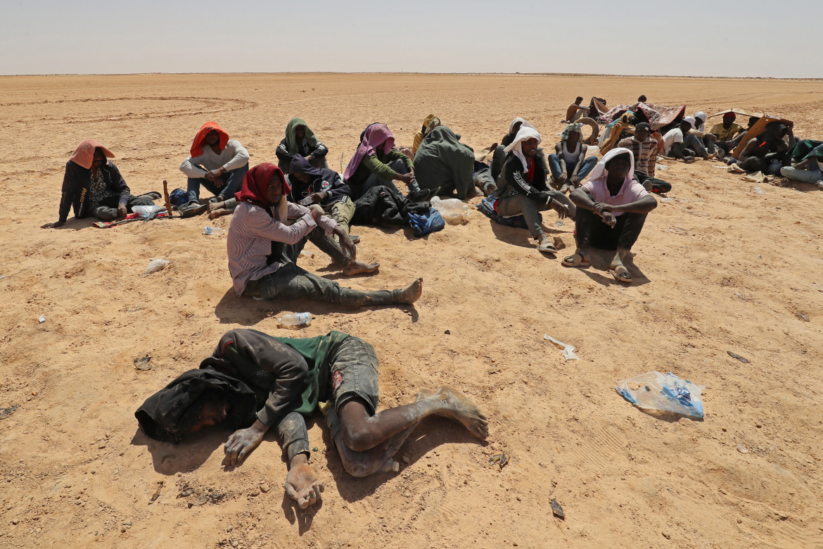 Migranti subsahariani, abbandonati nel deserto dalle autorità tunisine senza acqua o riparo, in un'area disabitata vicino alla città di confine libica Al-Assah, 16 luglio 2023 (Mahmud Turkia, Getty Images)