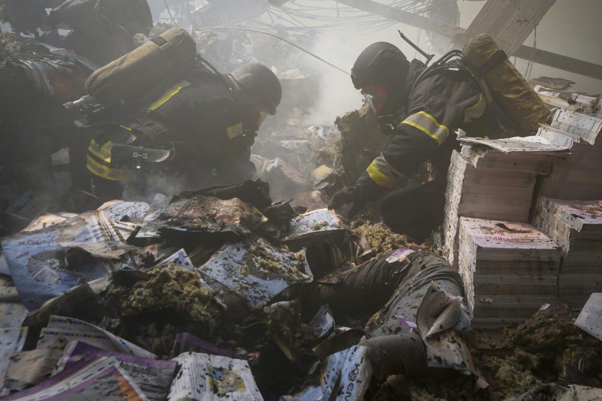 Squadre di soccorso tra le macerie dell’edificio colpito dai russi ieri a Kharkiv foto Andrii Marienko/Ap