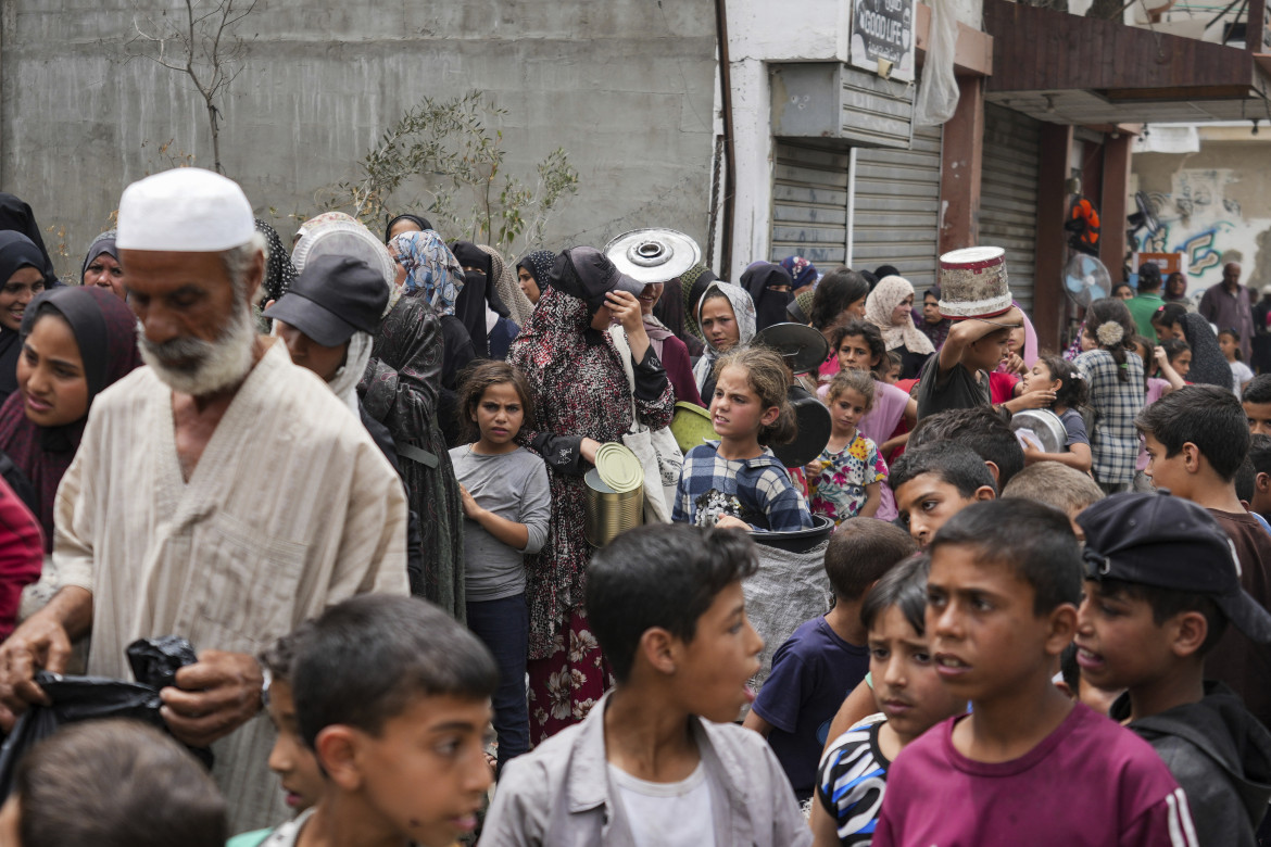 In fila per la distribuzione del cibo a Deir al Balah foto Ap/Abdel Kareem Hana