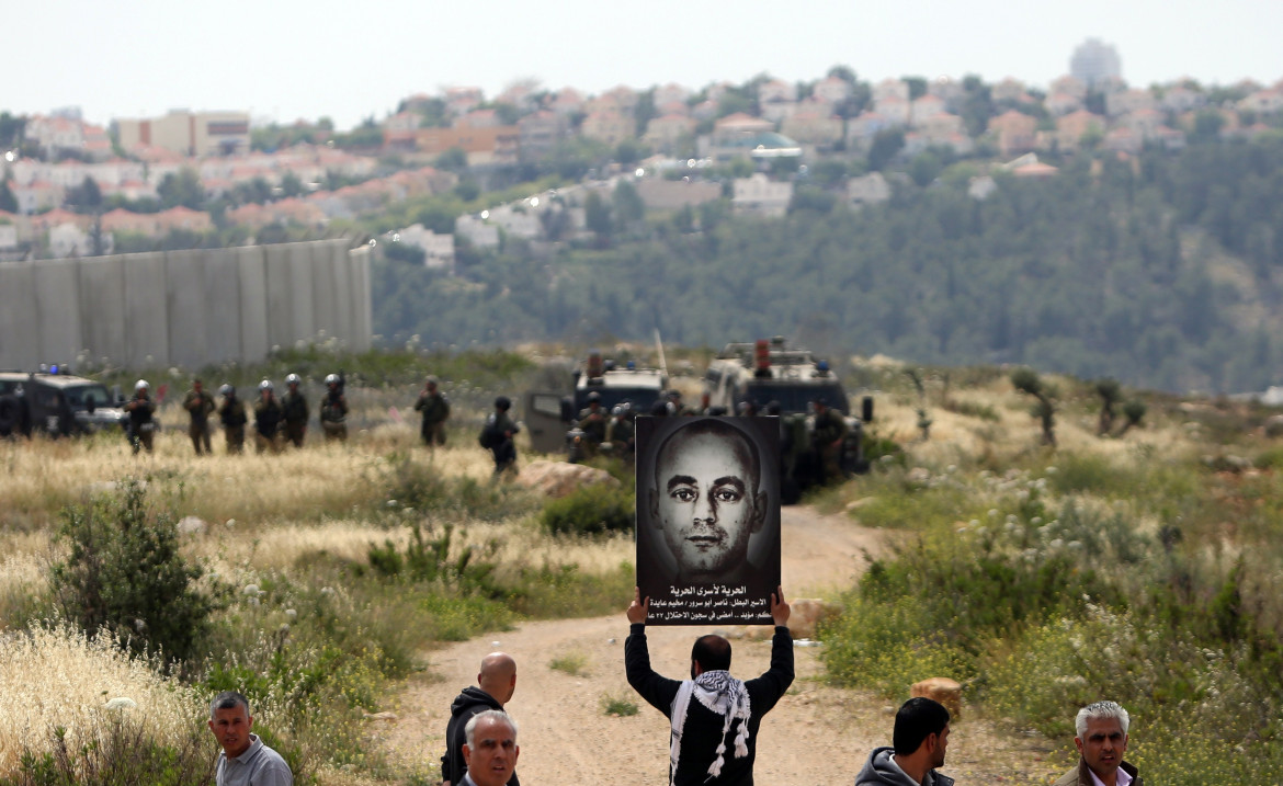 Una foto di Nasser Abu Srour viene mostrata durante una manifestazione del 2015 per la Giornata del prigioniero palestinese nella città di Bilin