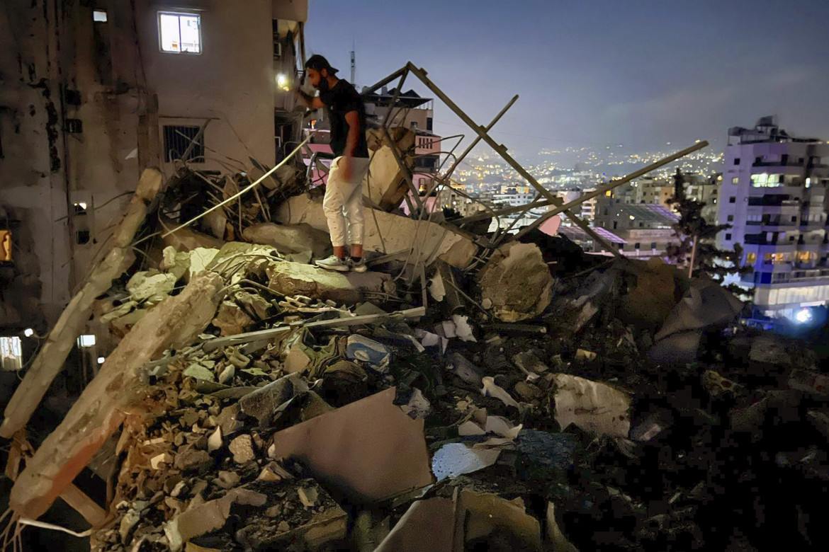 Un uomo ispeziona un edificio colpito da un attacco aereo israeliano nella periferia meridionale di Beirut in Libano