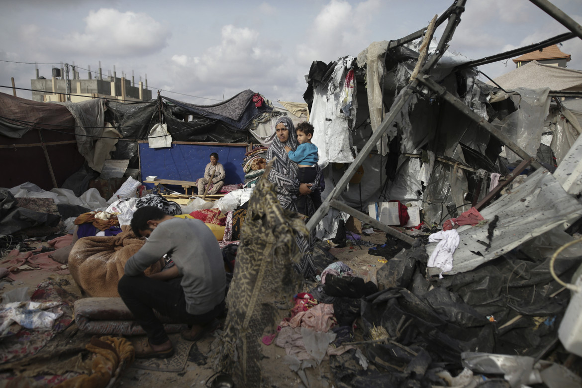 Palestinesi sfollati ispezionano le loro tende distrutte dai bombardamenti israeliani, presso una struttura dell'UNRWA a ovest della città di Rafah, nella Striscia di Gaza foto di Jehad Alshrafi, Ap