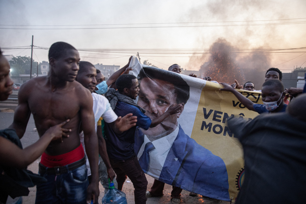 I manifestanti del quartiere Maxaquene manifestano a Maputo il 24 ottobre 2024 davanti a un manifesto di Venancio Mondlane foto GettyImage