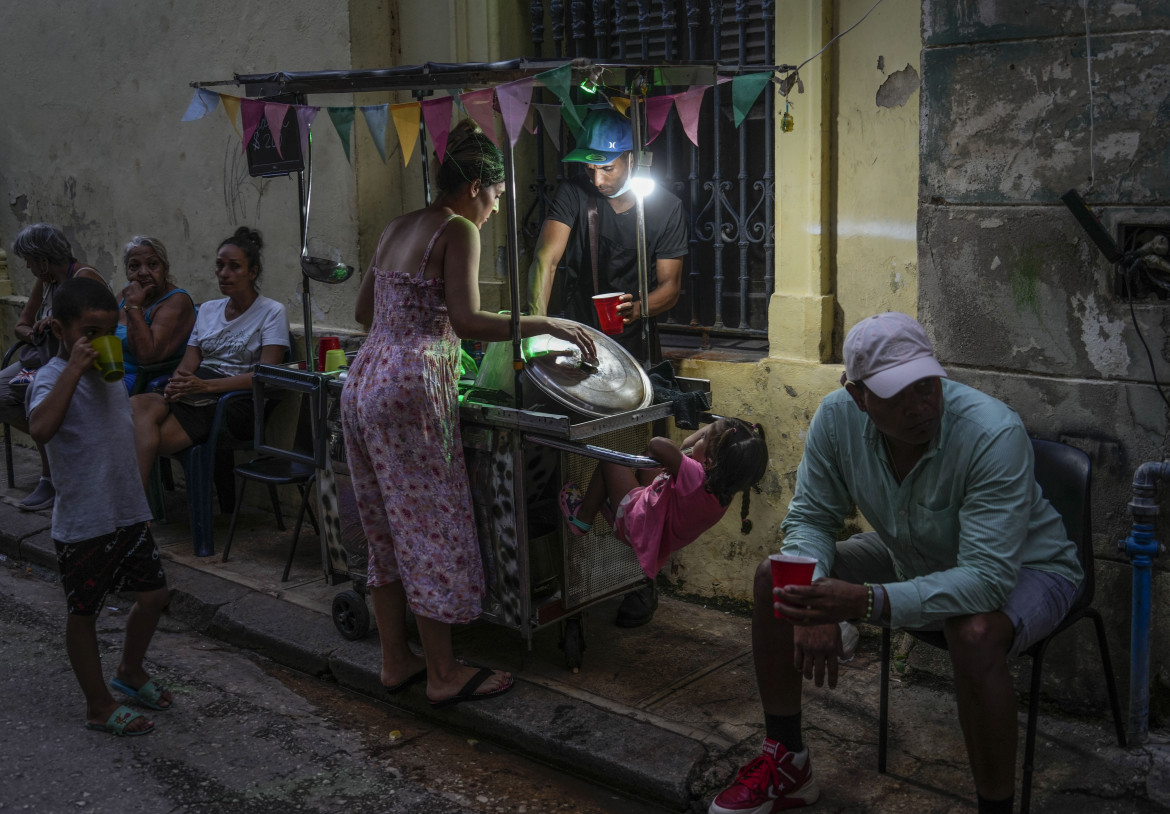 Una donna compra la zuppa da un venditore ambulante durante un'interruzione di corrente a L'Avana foto Ap