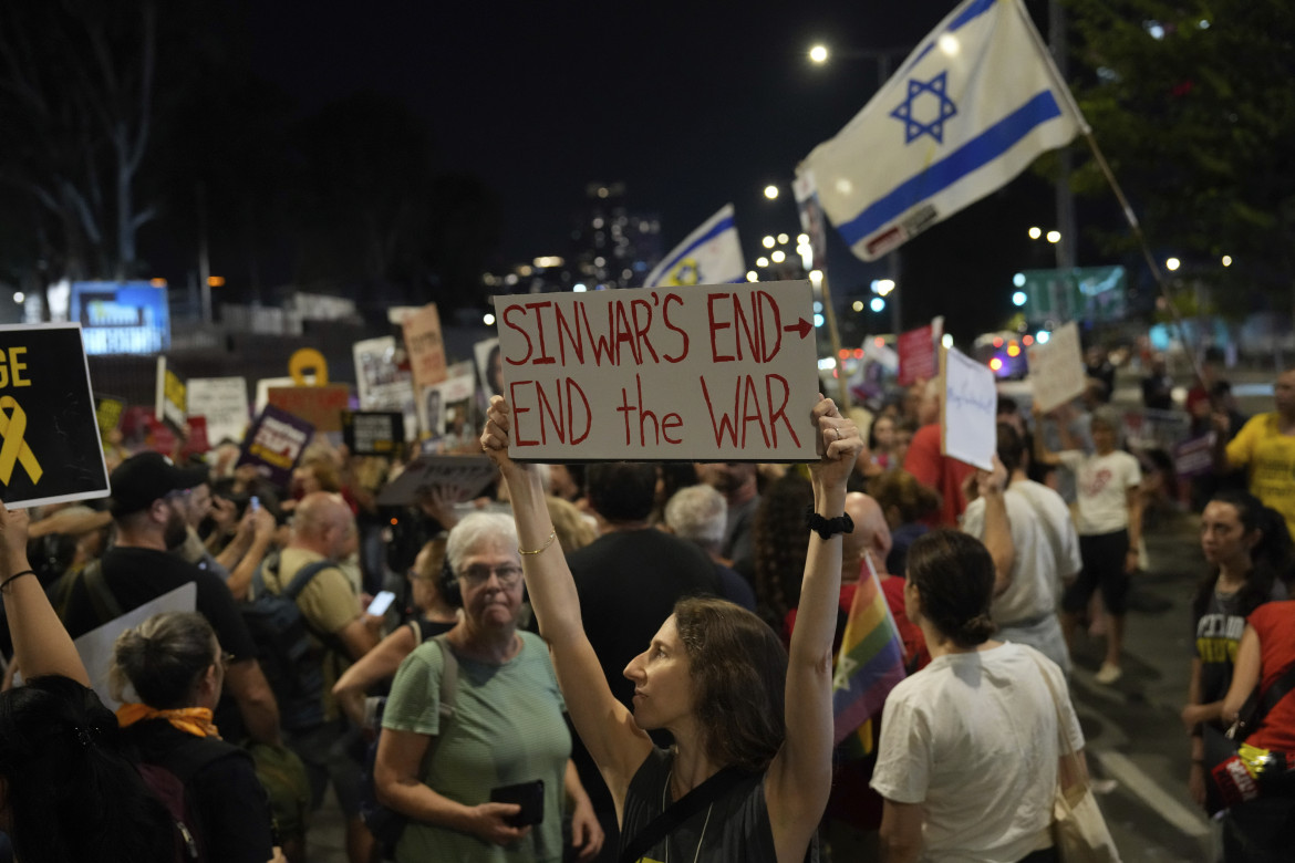 Un dimostrante regge un cartello sull'uccisione di Sinwar durante una protesta a Tel Aviv foto di Ariel Schalit/Ap