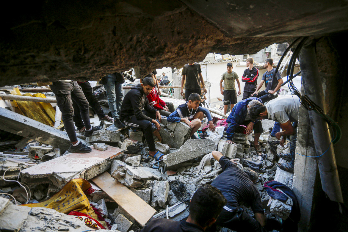 Un'operazione di ricerca e salvataggio per le persone rimaste bloccate sotto le macerie della casa distrutta dopo l'attacco israeliano al campo profughi di Al-Maghazi a Deir al-Balah, Gaza foto di Ashraf Amra/Getty Images