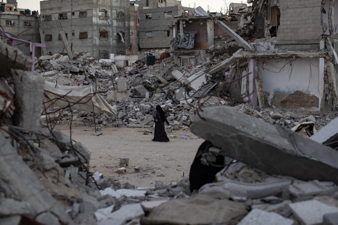 Una donna palestinese cammina tra le macerie di Khan Yunis a Gaza foto Ap