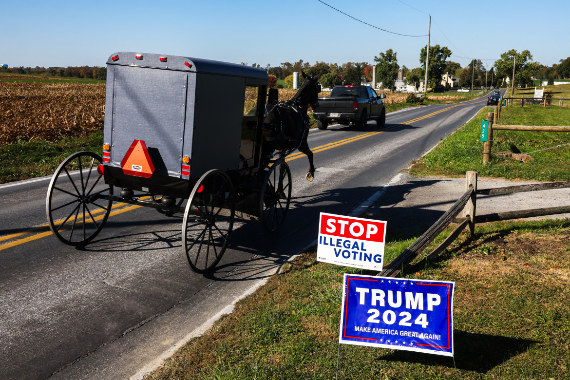 Un calesse degli Amish, che non usano automobili, in una strada di Strasburg, Pennsylvania, punteggiata dalla propaganda elettorale di Trump