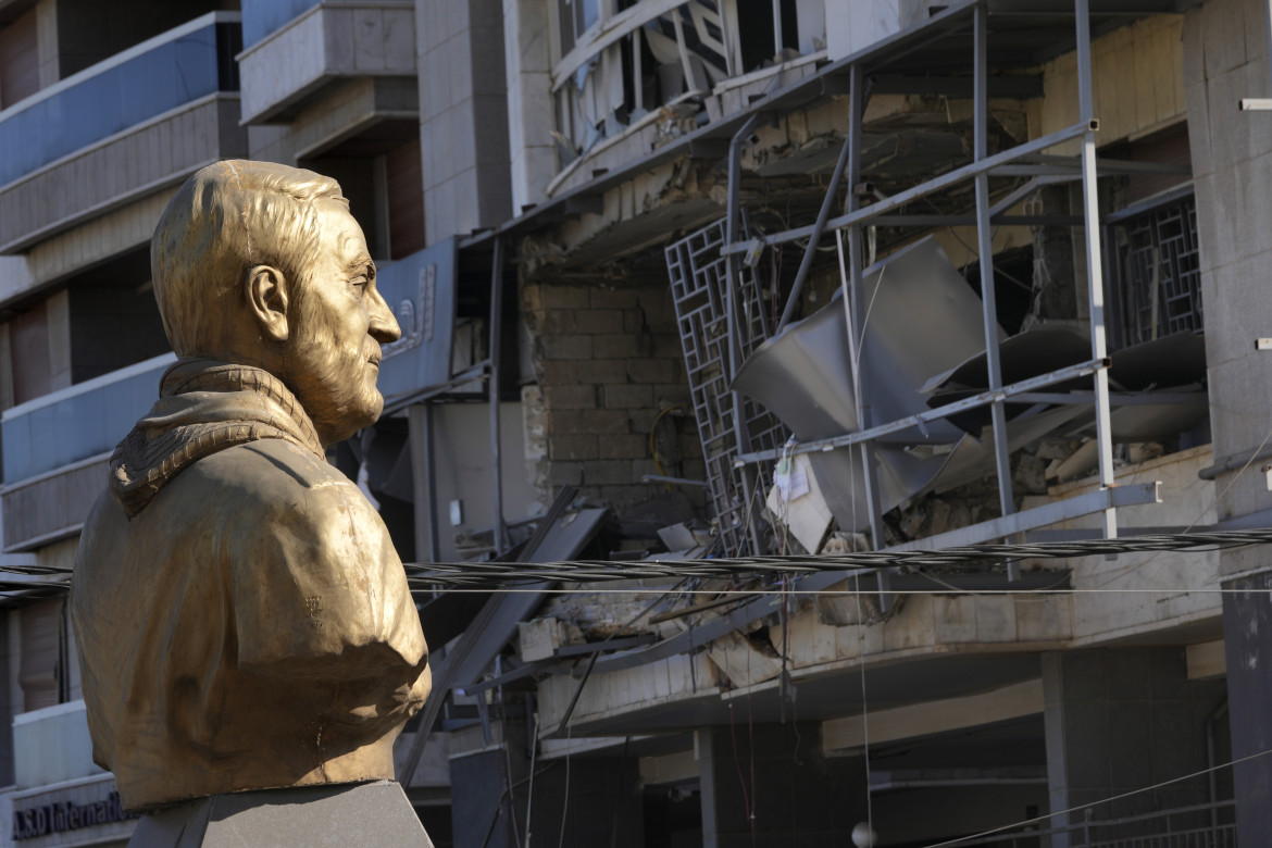 Il busto del generale iraniano Soleimani, uccisi nel 2020, di fronte a una sede di Hezbollah distrutta da un raid israeliano foto Ap