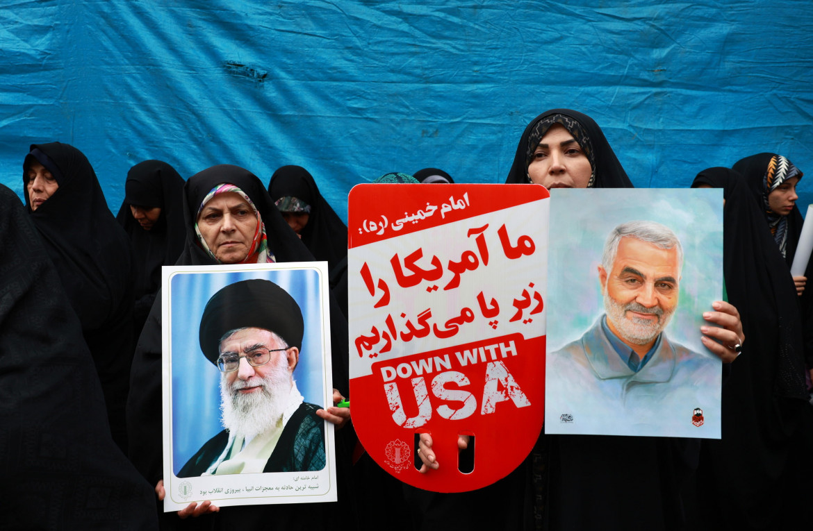 Donne iraniane tengono in mano le foto del leader iraniano Khamenei e Soleimani durante una manifestazione anti-Usa foto di Abedin Taherkenareh