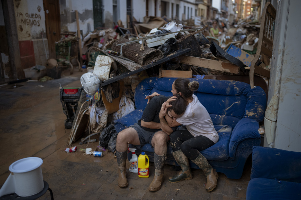 Due familiari si abbracciano dopo aver recuperato alcuni dei loro averi dalla casa allagata in seguito alle inondazioni di Paiporta, in Spagna foto di Emilio Morenatti/Ap