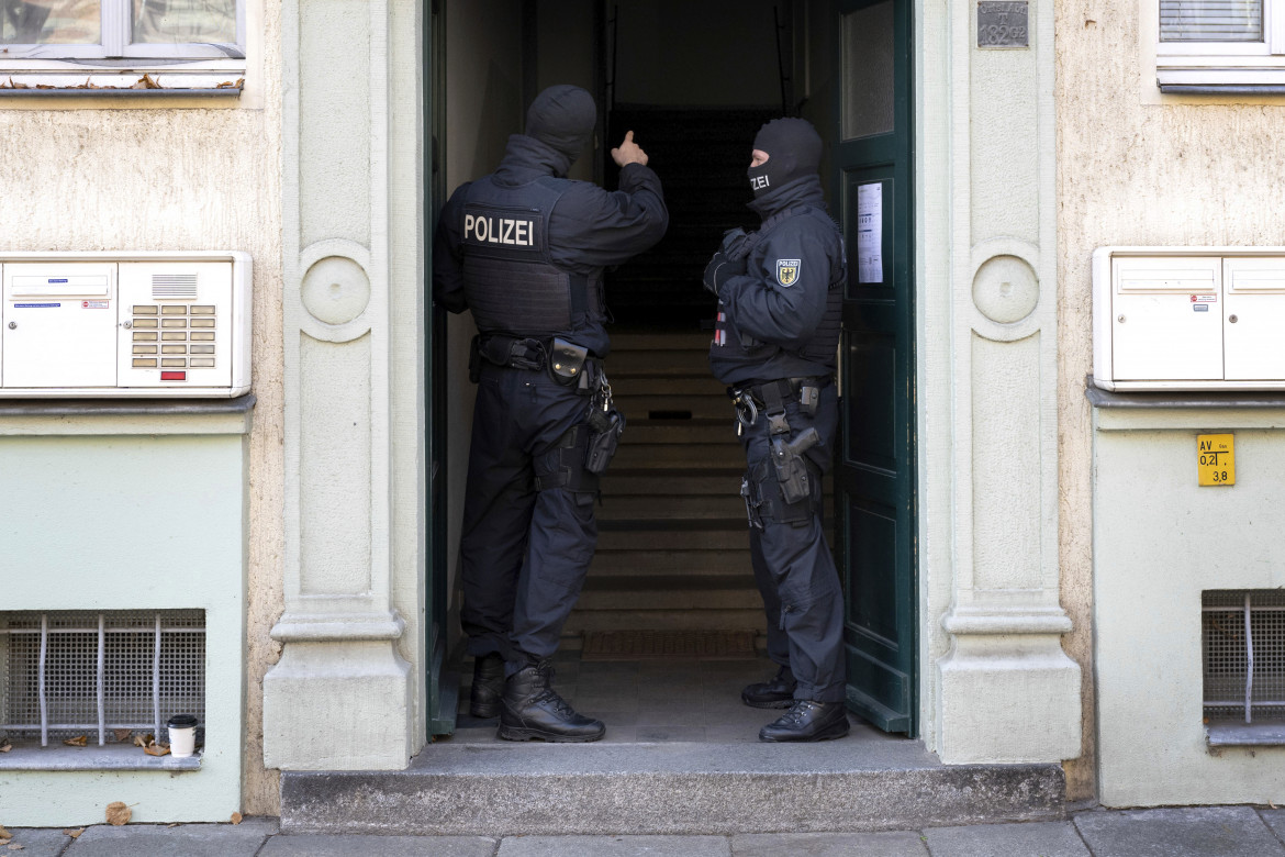 Agenti di polizia all'ingresso di un edificio durante un raid contro presunti membri di un'organizzazione di estrema destra a Dresda