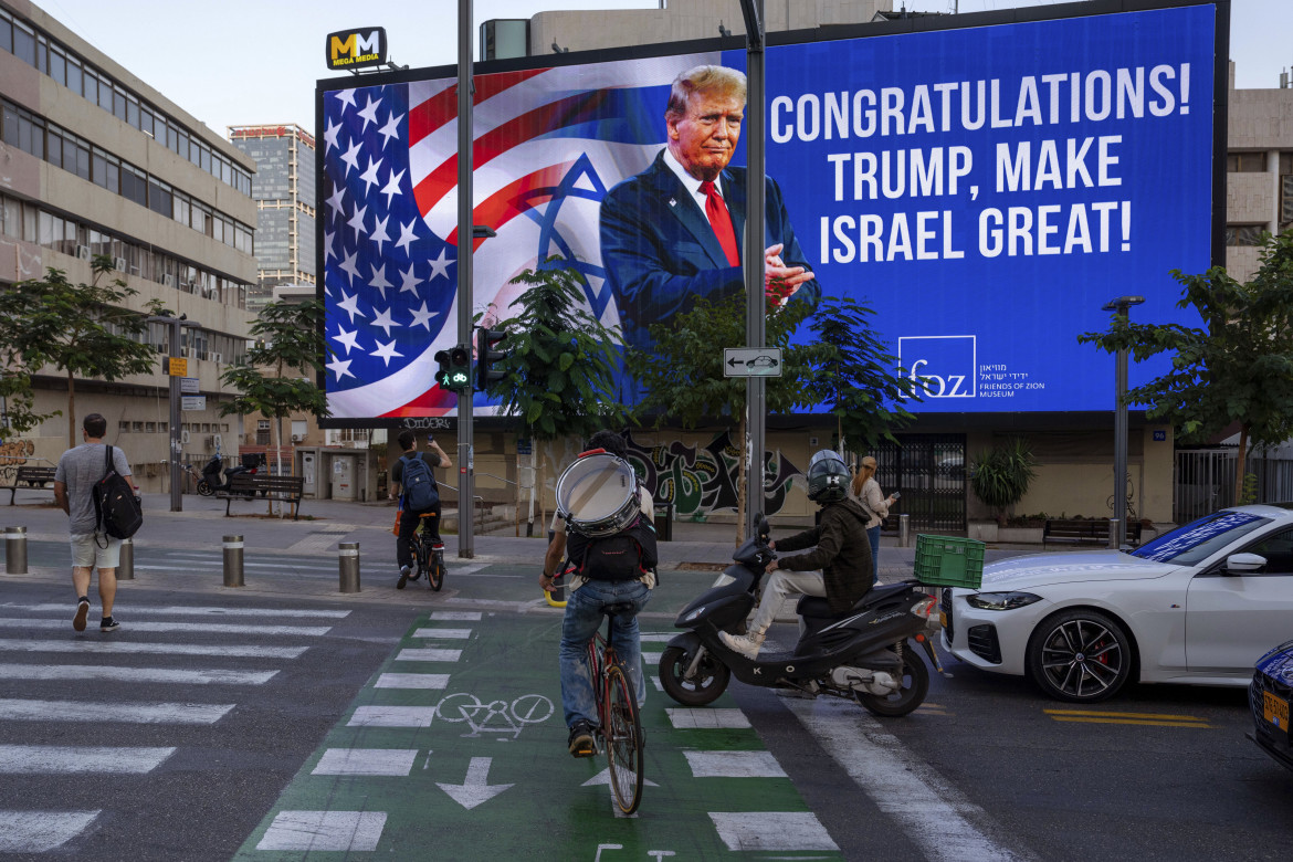 Un cartellone pubblicitario che mostra una foto di Donald Trump e recita Congratulazioni! Trump, rendi grande Israele - foto Ap