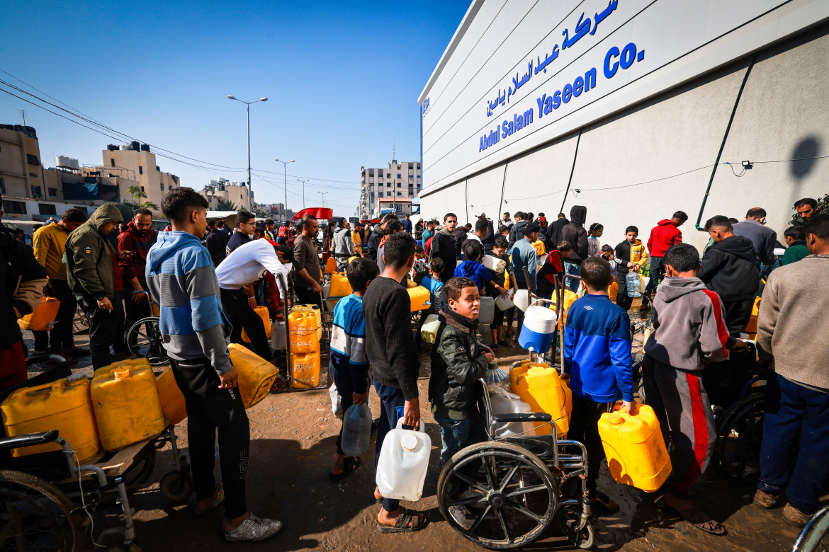 Un gruppo di palestinesi sfollati di Rafah attende la distribuzione dell'acqua da parte di un team di Medici Senza Frontiere (foto Msf)