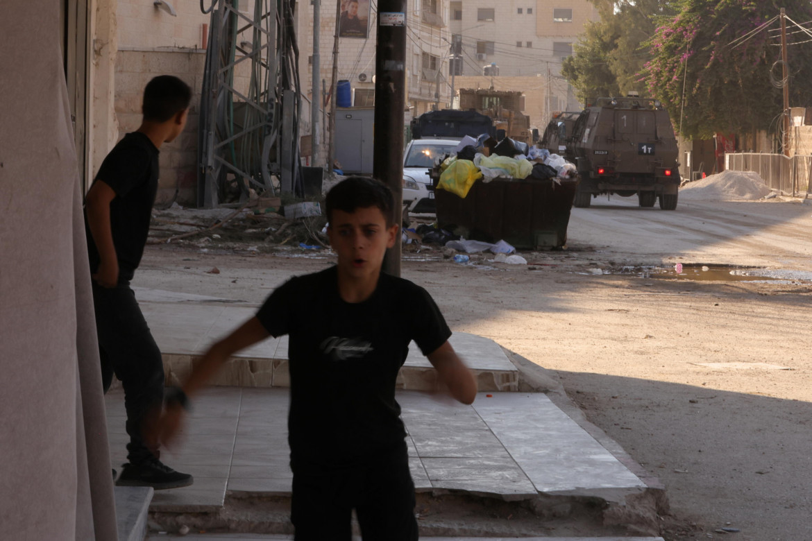 Un ragazzino palestinese scappa dai soldati israeliani a Jenin foto Epa/Alaa Badarneh