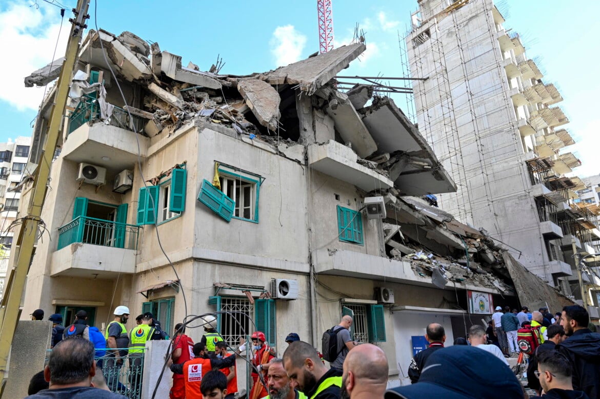 I soccorritori e la gente si radunano sul sito di un attacco aereo israeliano che ha preso di mira la sede del partito Baath nel quartiere Ras Al Naba'a di Beirut, in Libano foto Wael Hamzeh/Ansa