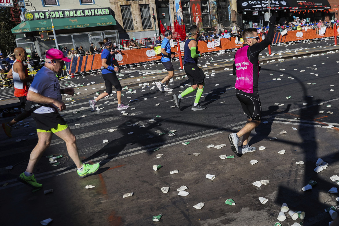 I corridori passano davanti a una stazione di Gatorade mentre attraversano Brooklyn durante la maratona di New York City (Heather Khalifa/Ap)