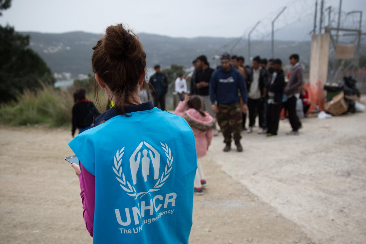 Un’operatrice Unhcr assiste dei migranti a Samos, in Grecia foto di Christian Charisius /Ap