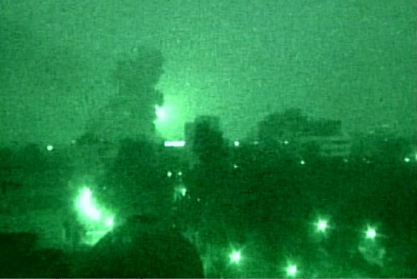 In this image from television via a nightscope, a cloud of smoke rises, at left, following a U.S.-led air strike attack on a target Thursday morning, March 20, 2003, near  Baghdad.  The U.S. used cruise missiles and precision-guided bombs during the attack.  (AP Photo/APTN)