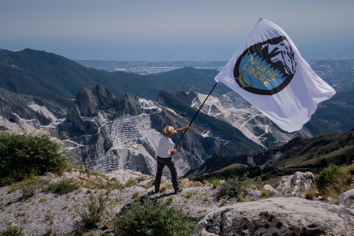 01-l-alpinista-ed-ambientalista-fiorentino-gianluca-briccolani-sventola-la-bandiera-dell-associazione-apuane-libere-durante-una-manifestazione-di-protesta-contr