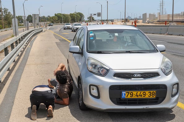 Al riparo durante il lancio di razzi di Hamas verso Tel Aviv foto Afp/Jack Guez