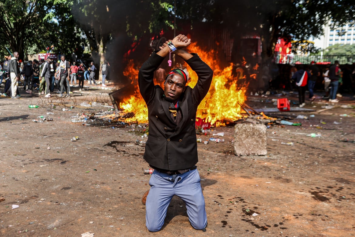 01-un-manifestante-si-inginocchia-mentre-alza-le-mani-durante-la-manifestazione-occupy-parliament-per-chiedere-lannullamento-della-nuova-legge-finanziaria-in-kenya-boniface-muthoni-z