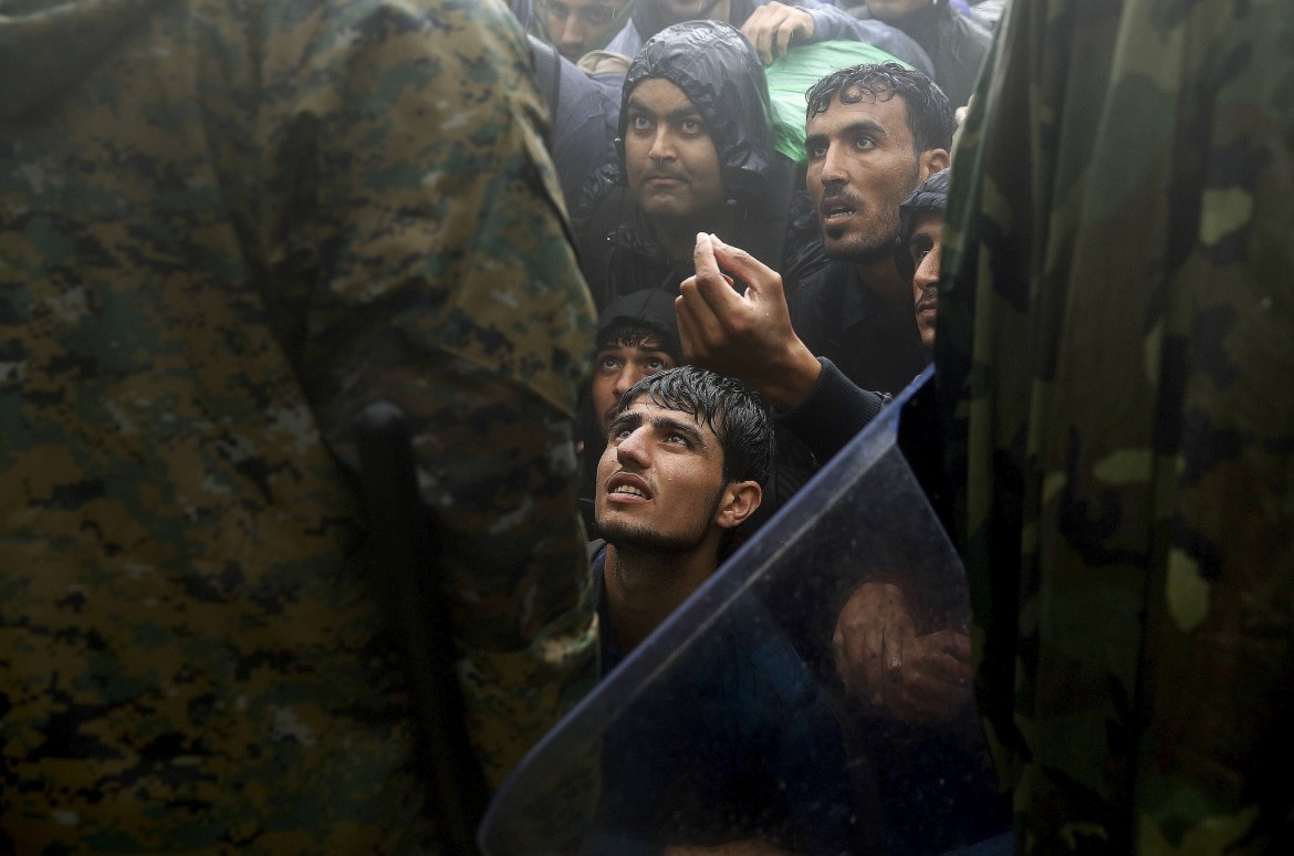 Migrants and refugees beg Macedonian soldiers to allow them passage to cross the border from Greece into Macedonia during a rainstorm, near the Greek village of Idomeni, September 10, 2015.  The number of refugees and migrants landing in Europe by sea crossing could reach 1 million this year, the U.N. says. Half of those arriving are Syrians fleeing war. Reuters Photographer Yannis Behrakis has documented migrants young and old arriving on the beaches of the Greek islands of Kos and Lesbos and as they travel overland through Greece, a stepping stone on their journey towards northern Europe. REUTERS/Yannis Behrakis