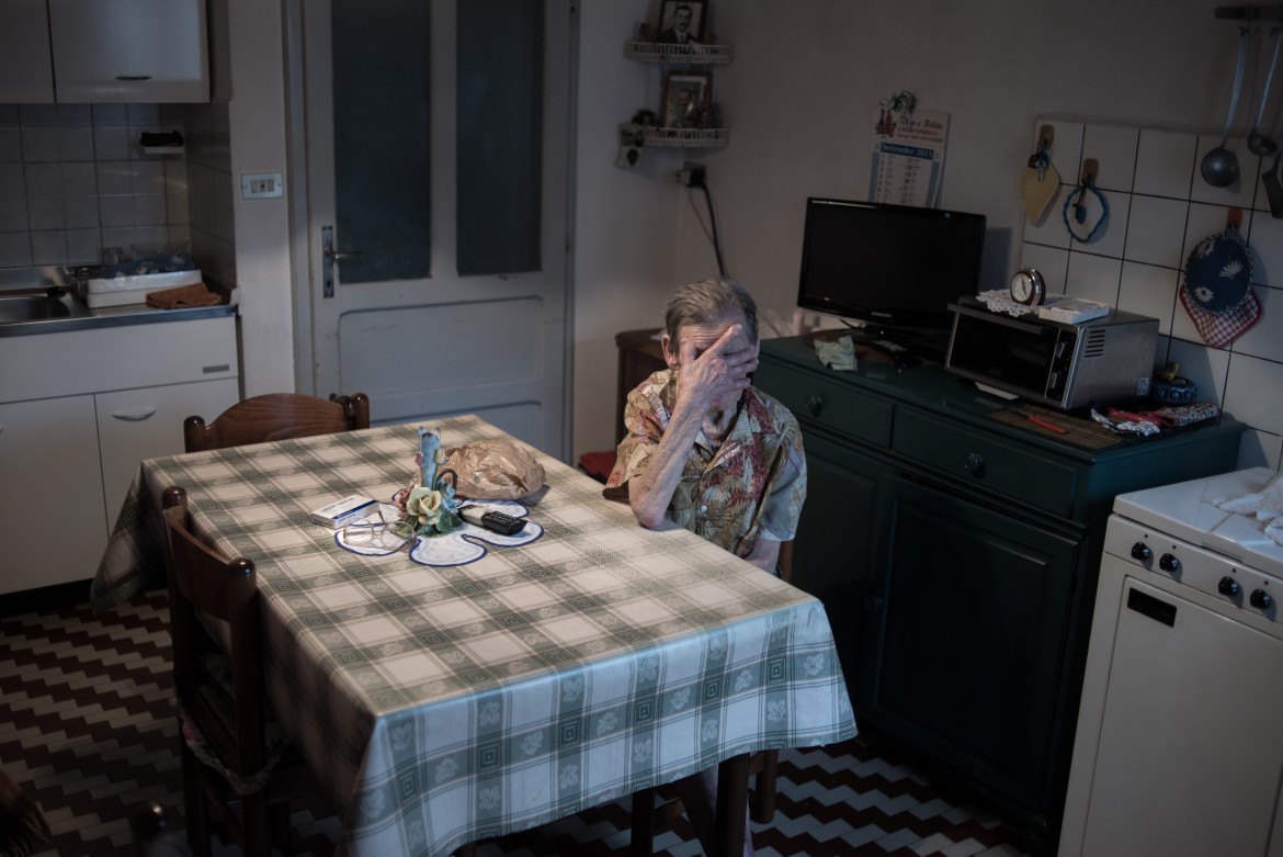 La signora Oliva, nella sua cucina. Morta solo nel 2014 all'età 95 anni è il simbolo della sopravvivenza e della permanenza degli abitanti di Casso. Fu trasportata in elicottero a Belluno. Non ha mai abbandonato la sua casa
