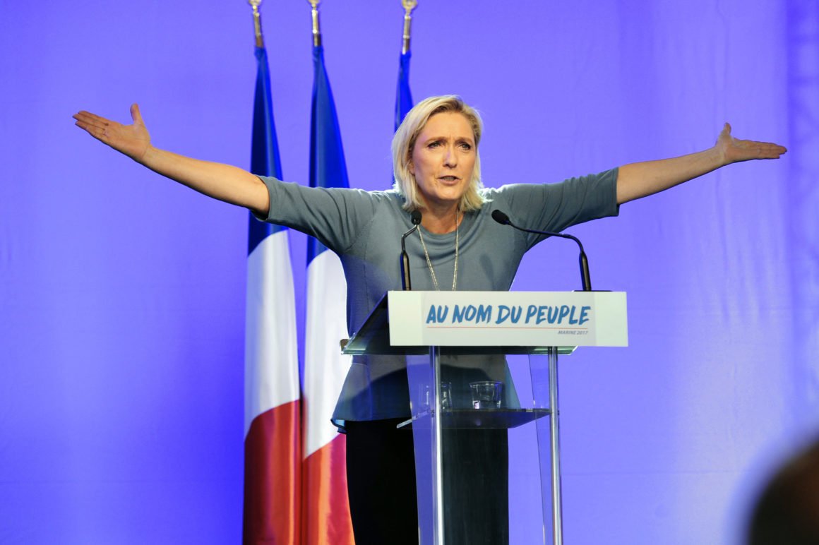 TOPSHOT - French far-right Front National (FN) party's President, Marine Le Pen, gestures as she delivers a speech on stage during the FN's summer congress in Frejus, southern France, on September 18, 2016. Marine Le Pen's slogan reading 