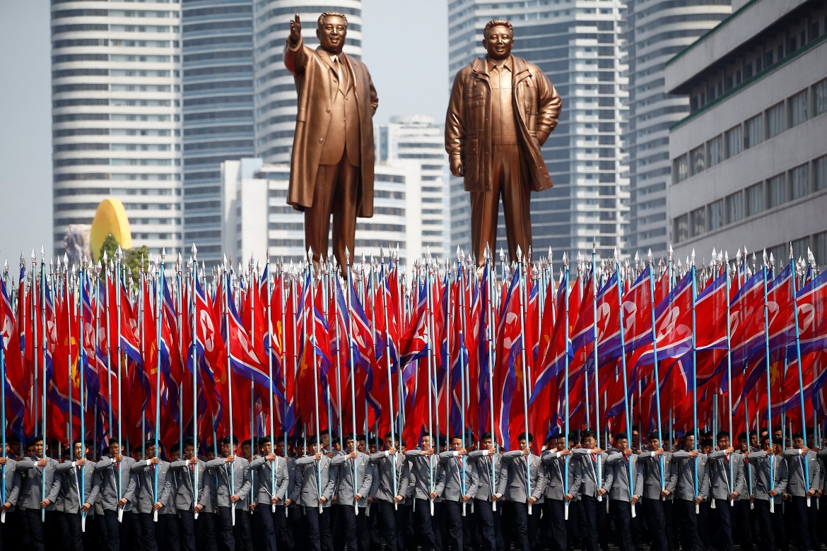 People carry flags in front of statues of North Korea founder Kim Il Sung (L) and late leader Kim Jong Il during a military parade marking the 105th birth anniversary Kim Il Sung in Pyongyang, April 15, 2017. REUTERS/Damir Sagolj     TPX IMAGES OF THE DAY