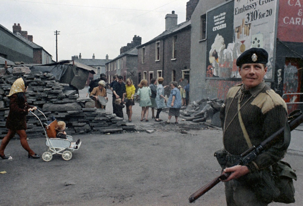 An armed British soldier in Belfast, Northern Ireland during disorders 1969. In the background are local people, AP