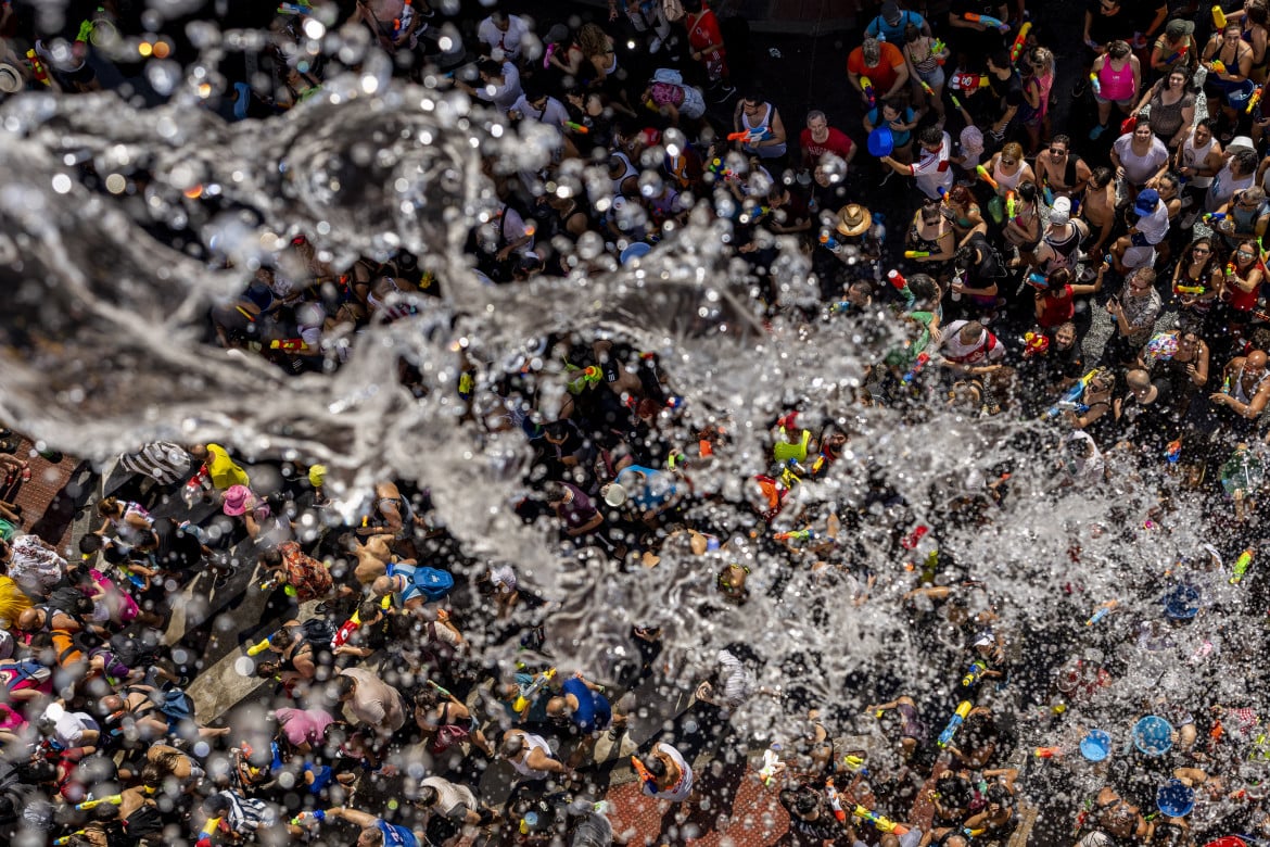 La tradizionale guerra dell'acqua a Vallecas (Madrid), foto Ap