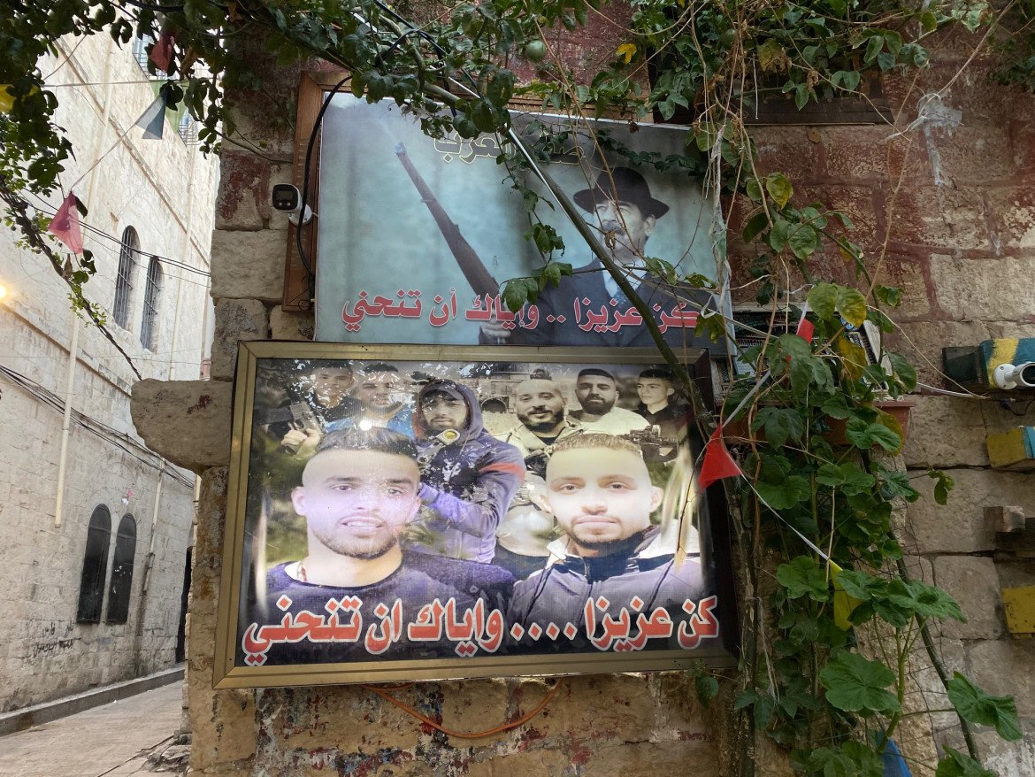 Poster di combattenti palestinesi sotto uno di Saddam Hussein (foto di Michele Giorgio)