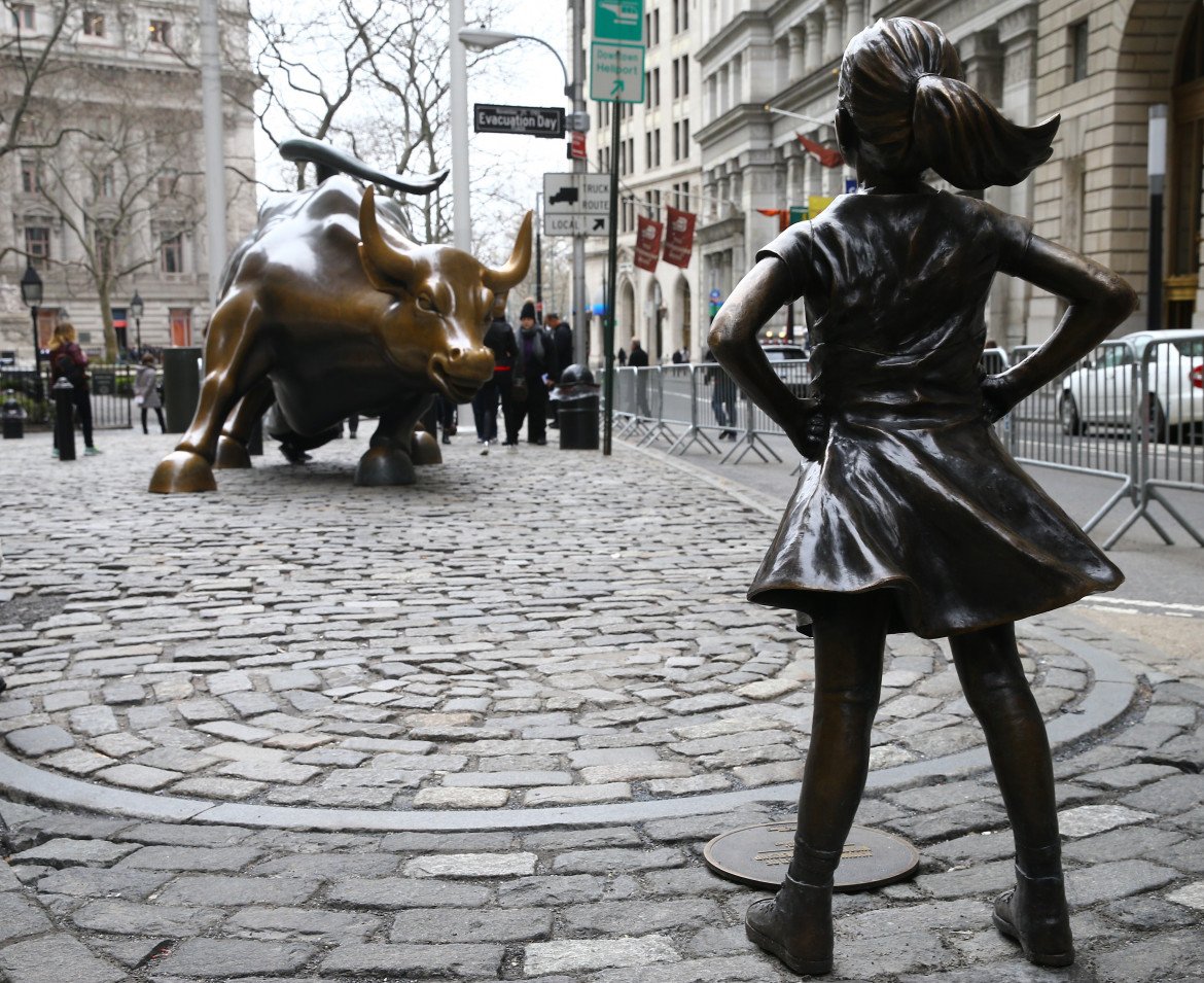 foto della scultura di una ragazza di fronte al toro di bronzo a Wall Street