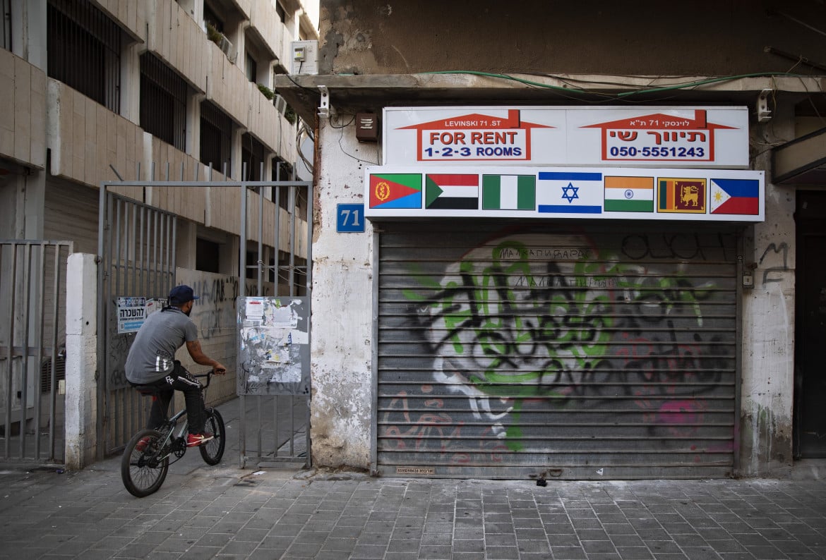 Tel Aviv, un migrante africano vicino a un’agenzia immobiliare chiusa foto Ap/Oded Balilty