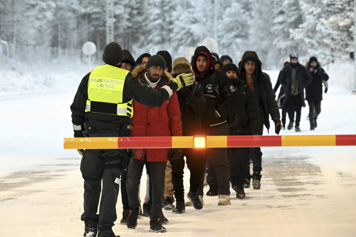 Una guardia di frontiera finlandese ferma i migranti al valico di frontiera internazionale tra Finlandia e Russia foto Ap