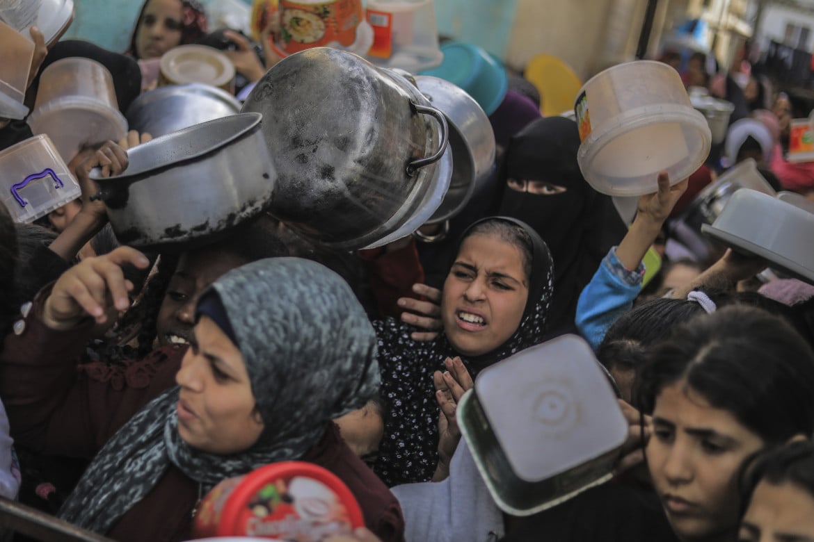 In fila per il cibo cucinato da un gruppo di volontari a Khan Yunis foto Ap/Mohammed Talatene