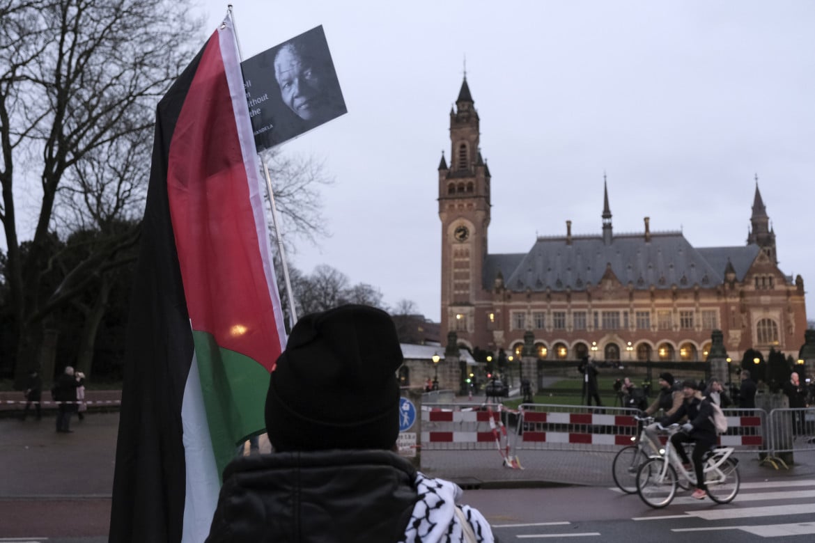 Manifestante con la bandiera palestinese e il volto di Mandela di fronte alla Corte dell’Aja Ap/Patrick Post