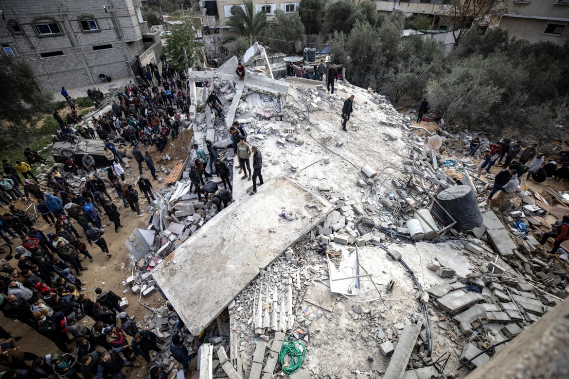 La ricerca di superstiti sotto le macerie di un edificio distrutto a Rafah